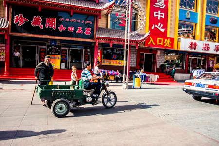Urumqi, China - 23 June, 2009: Elderly man crossing a street in downtown district on a summer dayのeditorial素材