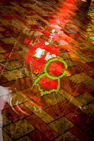 Hong Kong, China - 28 May, 2009: Neon lights for a noodle shop reflected in a rain puddle in Mongkok...