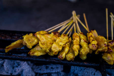 Chicken satay grilling over hot coalsの写真素材