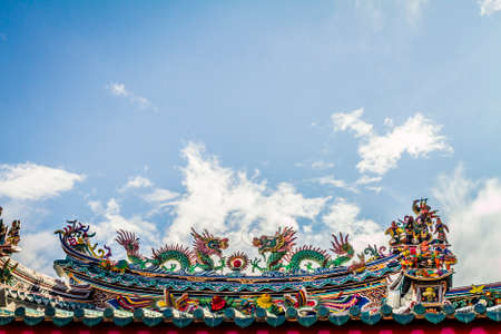 Temple rooftop against a blue sky with cloudsの写真素材