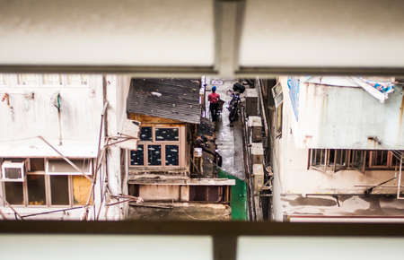 Man walking through a break between buildings in Hong Kongの写真素材