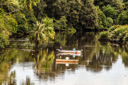 Fishing boats in a jungle river on the interior of Borneo.の写真素材
