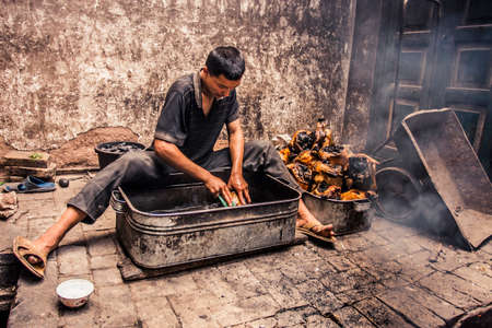 Kashgar, China - 28 June, 2009: Uyghur family cleaning the heads of lambs at the Sunday Market in old town Kashgarのeditorial素材
