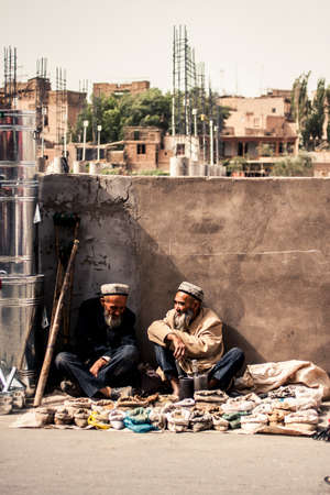 Kashgar, China - 28 June, 2009: Old Uyghur men selling spices on the side of a small road at the...