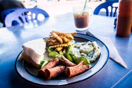 Malaysian breakfast with sausages, egg, toast and friesの写真素材