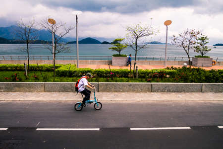 Hong Kong, China - 6 March 2010: Man riding a miniature bicycle on a path in Sha Tinのeditorial素材