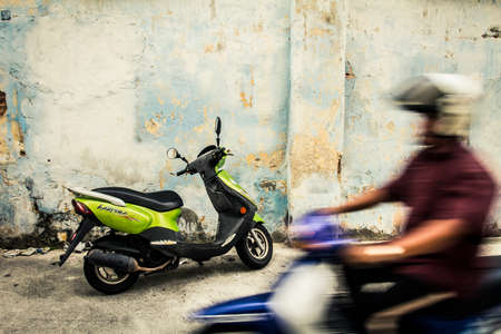 Penang, Malaysia - 3 June, 2010: Scooter parked next to a wall in the colonial district of Penang...
