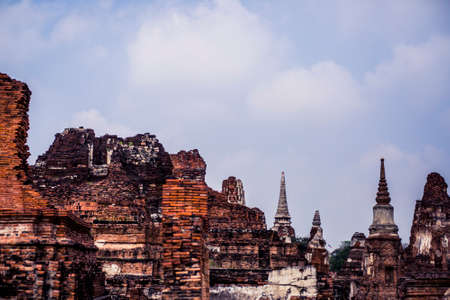 Ancient ruins with carved stone buddhas and temples at the Ayutthaya Historical Park in Thailandの写真素材