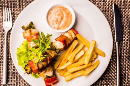 Grilled chicken kebab with chips and vegetables
