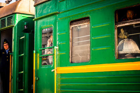Ulaanbaatar, Mongolia - 2 June, 2013: Passengers visible through windows on the antiquated train heading out from Central Station to Beijingのeditorial素材