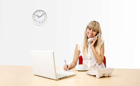 Secretary with a telephone in the officeの写真素材