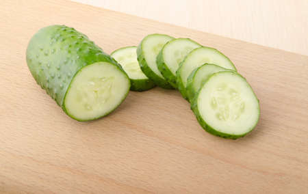 Cucumber and Slices on a cutting boardの写真素材