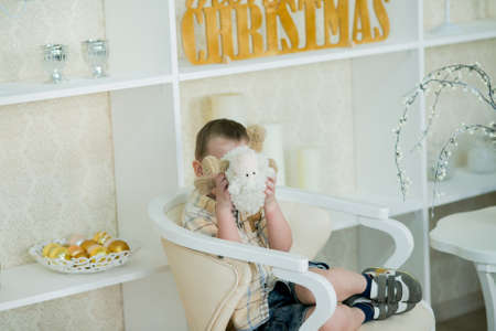 Cheerful little boy playing with a toy lambの写真素材