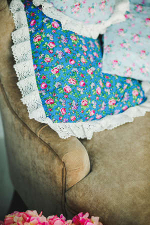 Closeup photo of pillow with floral print on big bedの写真素材