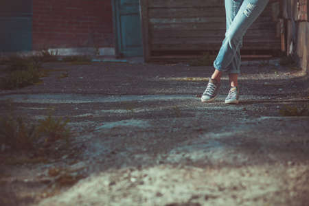 eans and sneakers on women's feetの写真素材