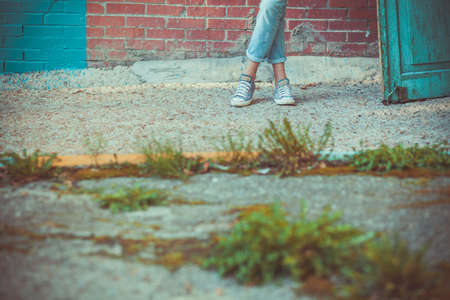 eans and sneakers on women's feetの写真素材