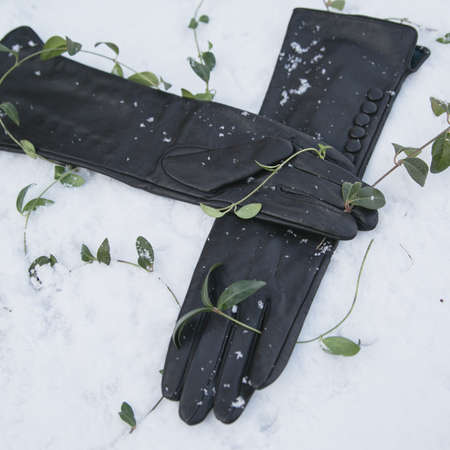 Woman's hands in red gloves on winter natural backgroundの写真素材