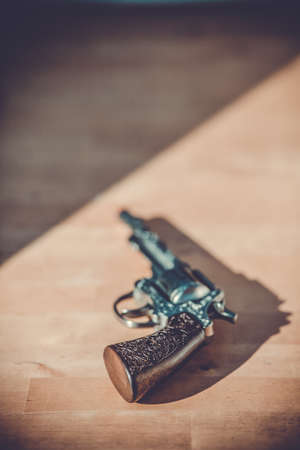 vintage gun lying on a wooden tableの写真素材