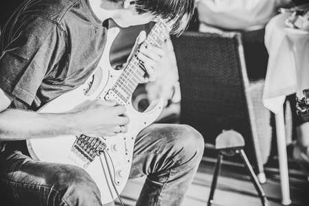 Practicing in playing guitar. Handsome young men playing guitarの写真素材