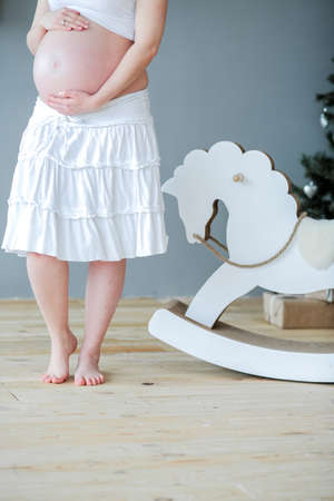 belly of pregnant woman with red ribbon and bow.の写真素材