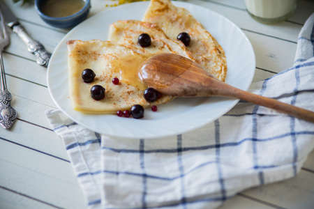 on wooden white background pancakes on a plateの写真素材