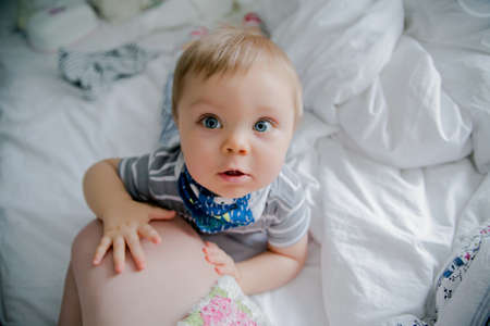 the child looks at the mother with large blue eyesの写真素材