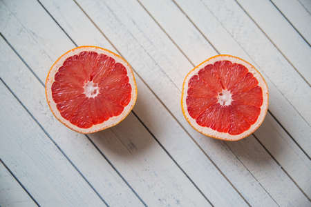 the grapefruit and Apple lying on a white wooden backgroundの写真素材