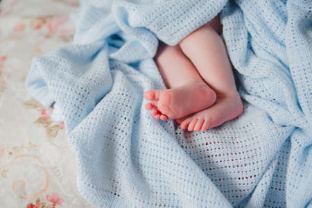 Close up photo from a baby's leg in her mother's handの写真素材