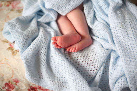 Close up photo from a baby's leg in her mother's handの写真素材