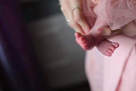 Close up photo from a baby's leg in her mother's handの写真素材