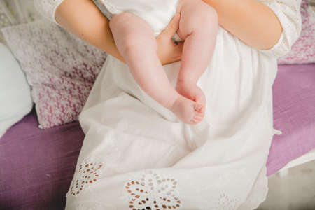 Close up photo from a baby's leg in her mother's handの写真素材