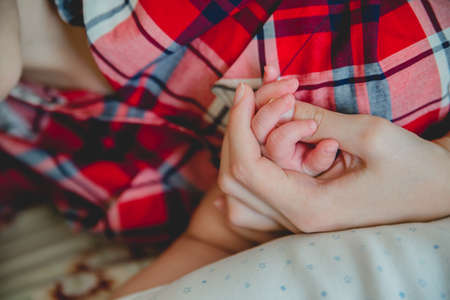 father and mother hold in their hands a little newborn baby'sの写真素材