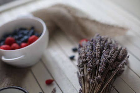 oatmeal porridge, bottle of milk and berries on wooden background with kitchen towel, top viewの写真素材