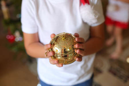 Children's hands holding a red Christmas decoration isolated on white backgroundの写真素材