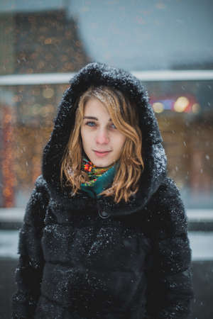 Cute young woman playing with snow in fur coat outdoorsの写真素材