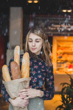 woman holding baguettes of bread in his handの写真素材