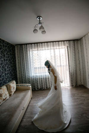 Portrait of the beautiful bride against a window indoorsの写真素材