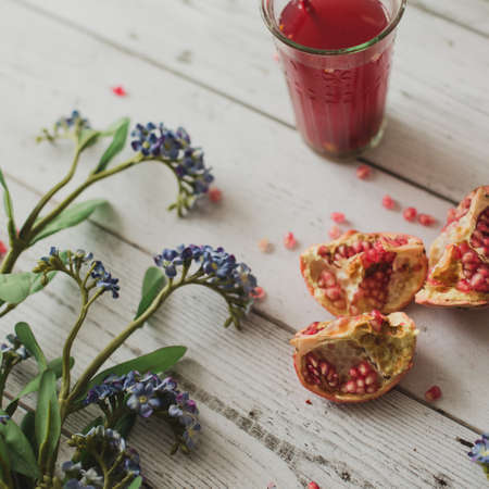 glass of pomegranate juice with fresh fruits on wooden tableの写真素材