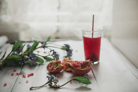 glass of pomegranate juice with fresh fruits on wooden tableの写真素材