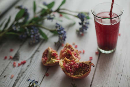 glass of pomegranate juice with fresh fruits on wooden tableの写真素材