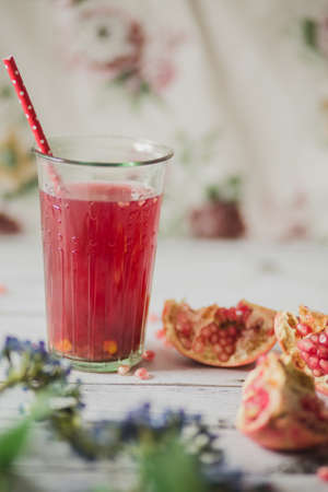 glass of pomegranate juice with fresh fruits on wooden tableの写真素材