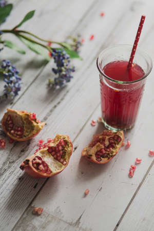 glass of pomegranate juice with fresh fruits on wooden tableの写真素材