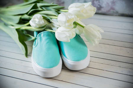 Female shoes with flowers on wooden background