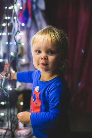 the little boy with the twinkle lights near the mirrorの写真素材