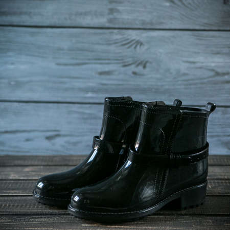 rubber boots on wooden background