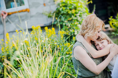 Happy loving family. Mother and daughter on the street embracingの写真素材