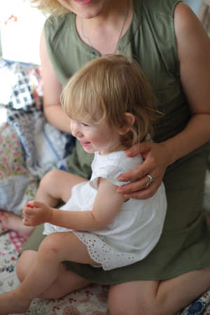 Caring young mother breastfeeds adult babyの写真素材