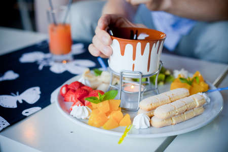 chocolate fondue with fruits in blue potの写真素材