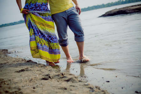 man and woman couple standing on the beach near the waterの写真素材