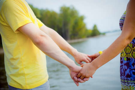 Closeup of couple holding hands standing in waterの写真素材